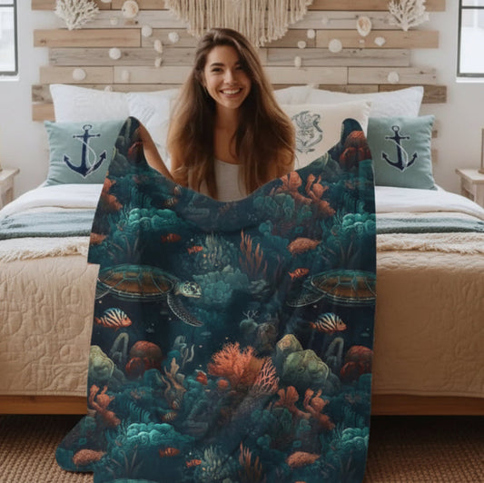 Our Velveteen Plush Blanket with a dark underwater scene with coral, fish and sea turtles.