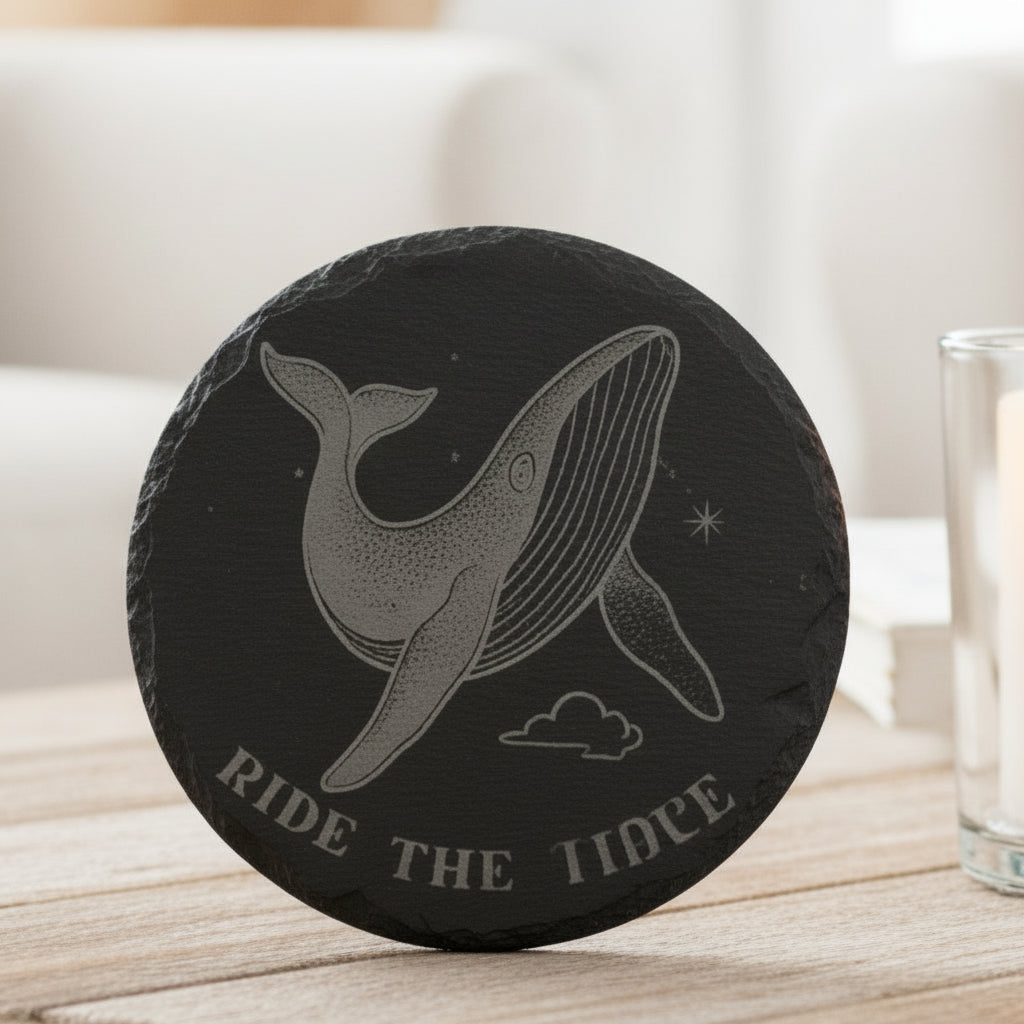 Black engraved slate coaster with whale and text Ride the Tide.