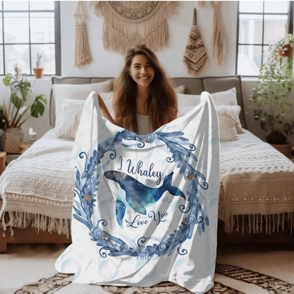 White Velveteen Plush blanket with blue marine plant wreath with swimming whale in the middle and text I Whaley Love You -perfect for snuggling up with your beachy loved ones!