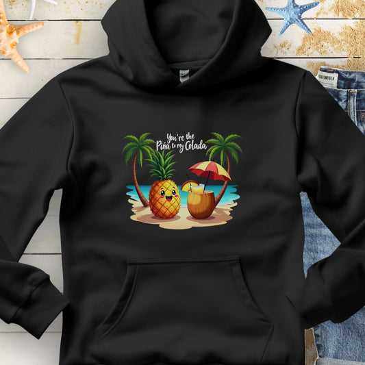 Black Hoodie with a pineapple and a coconut pina colada on a beach between two palm trees with the text You're the Pina to my Colada.