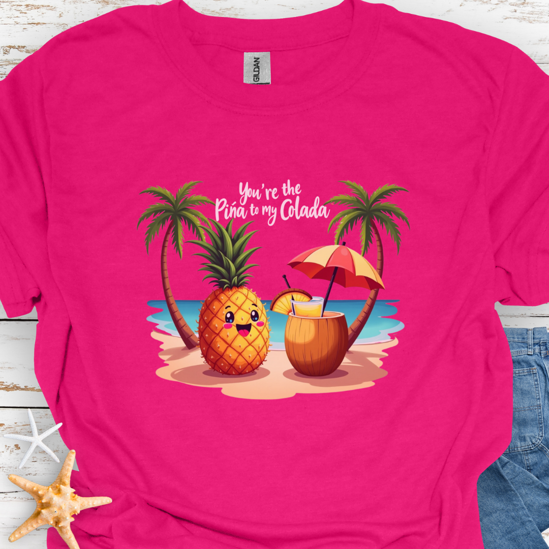 Heliconia T-shirt with a pineapple and a coconut pina colada on a beach between two palm trees with the text You're the Pina to my Colada.