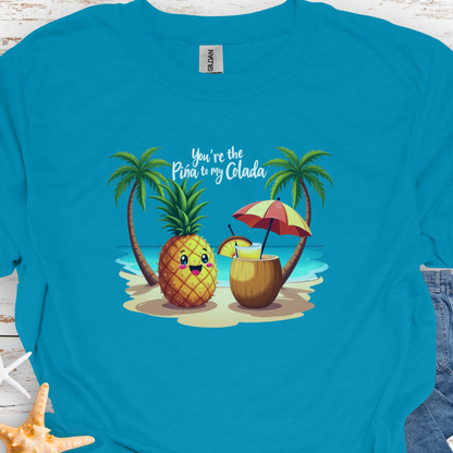 Tropical Blue T-shirt with a pineapple and a coconut pina colada on a beach between two palm trees with the text You're the Pina to my Colada.