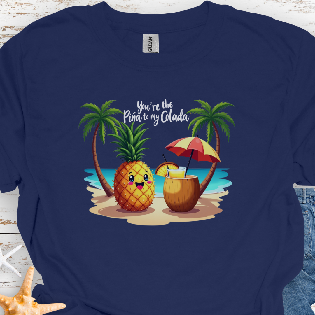 Navy T-shirt with a pineapple and a coconut pina colada on a beach between two palm trees with the text You're the Pina to my Colada.