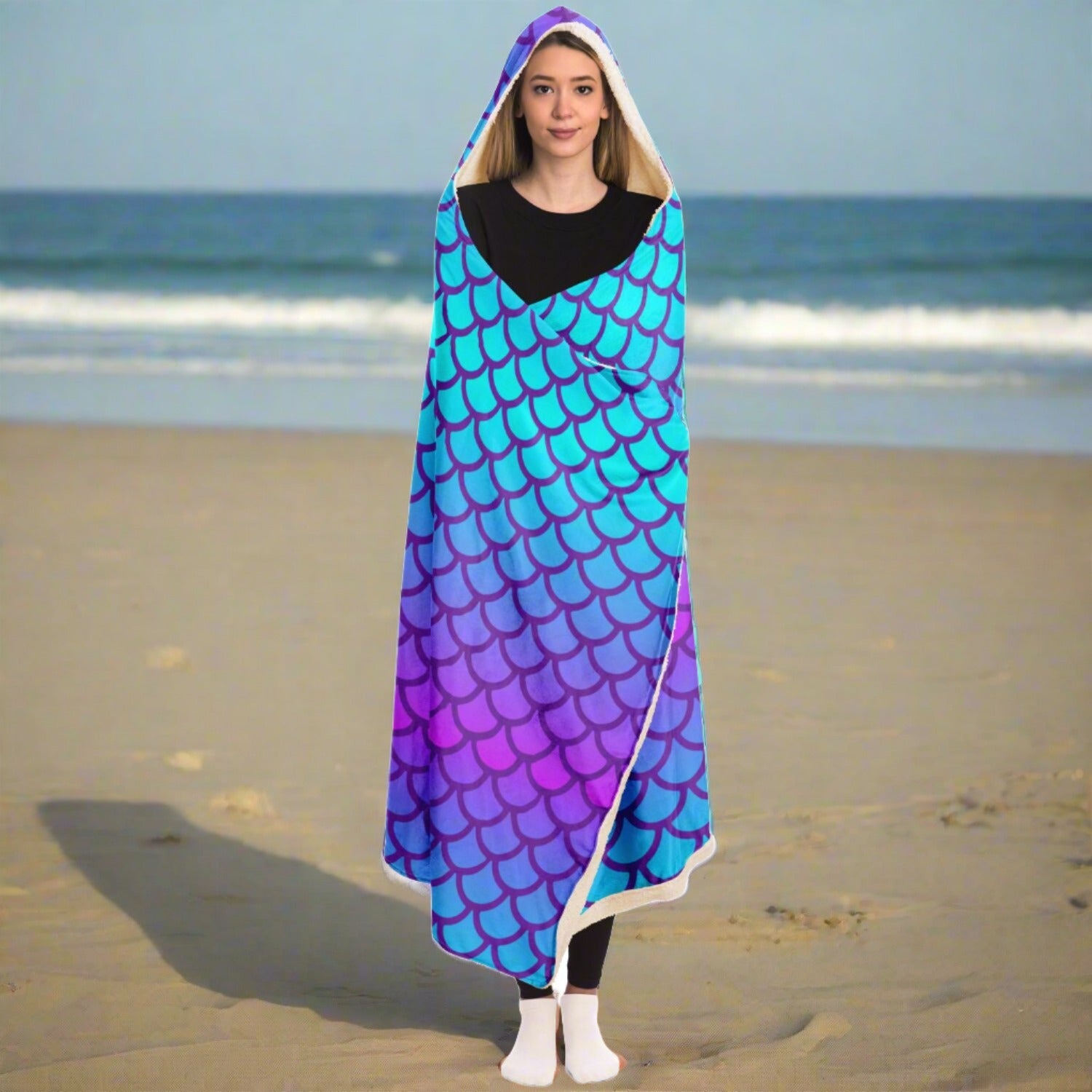 Person wearing a hooded blanket with mermaid scales in purple and turquoise with a picture of a beautiful mermaid with the words mermaid vibes below