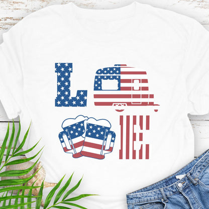 White T-shirt with patriotic LOVE design: blue star-patterned L, American flag camper as O, beer mugs forming V, and red-striped E – playful 4th of July theme.
