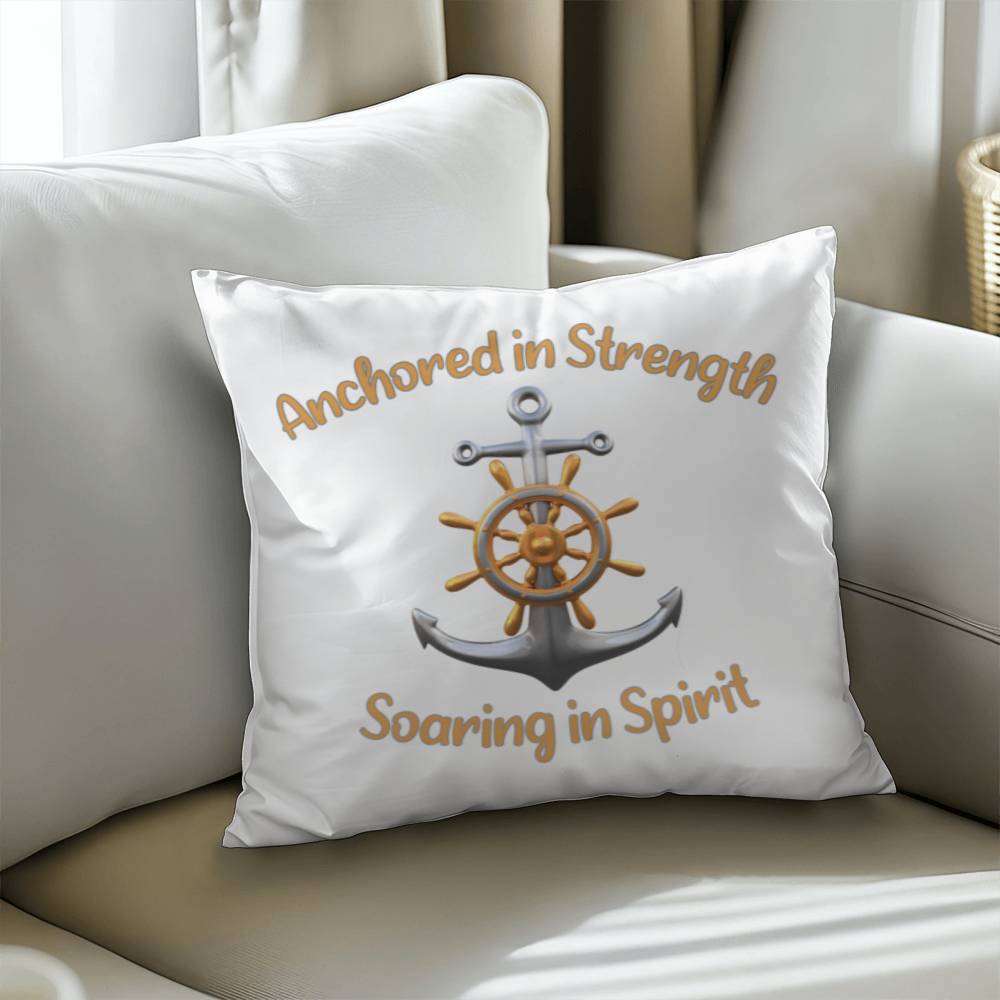 White pillow with a picture of an anchor and the words Anchored in Strength Soaring in Spirt surrounding sitting on a couch