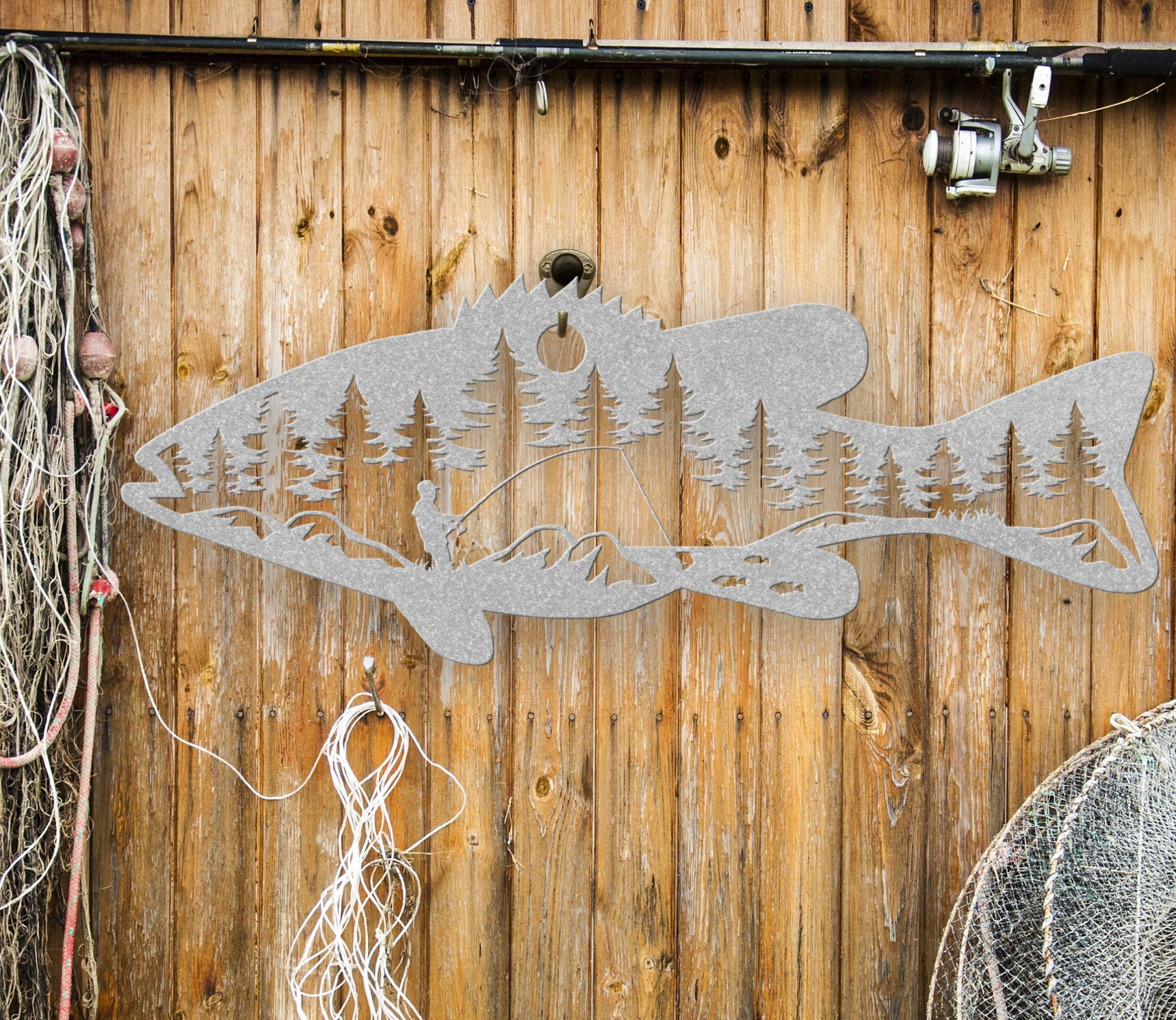 Silver  intricate metal art sign featuring a bass fish with a man fishing inside the fish. A unique and detailed design, perfect for fishing enthusiasts and rustic home or cabin decor.