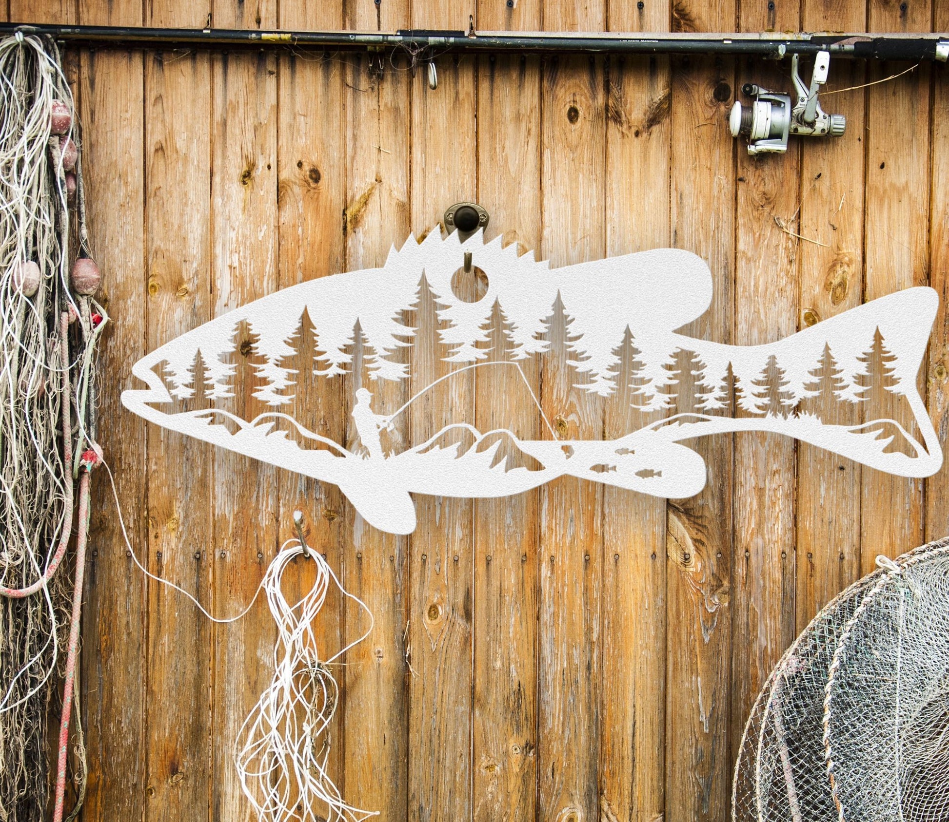 White  intricate metal art sign featuring a bass fish with a man fishing inside the fish. A unique and detailed design, perfect for fishing enthusiasts and rustic home or cabin decor.