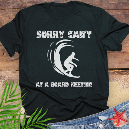 Black t-shirt with a surfer and says Sorry Can't Board Meeting.