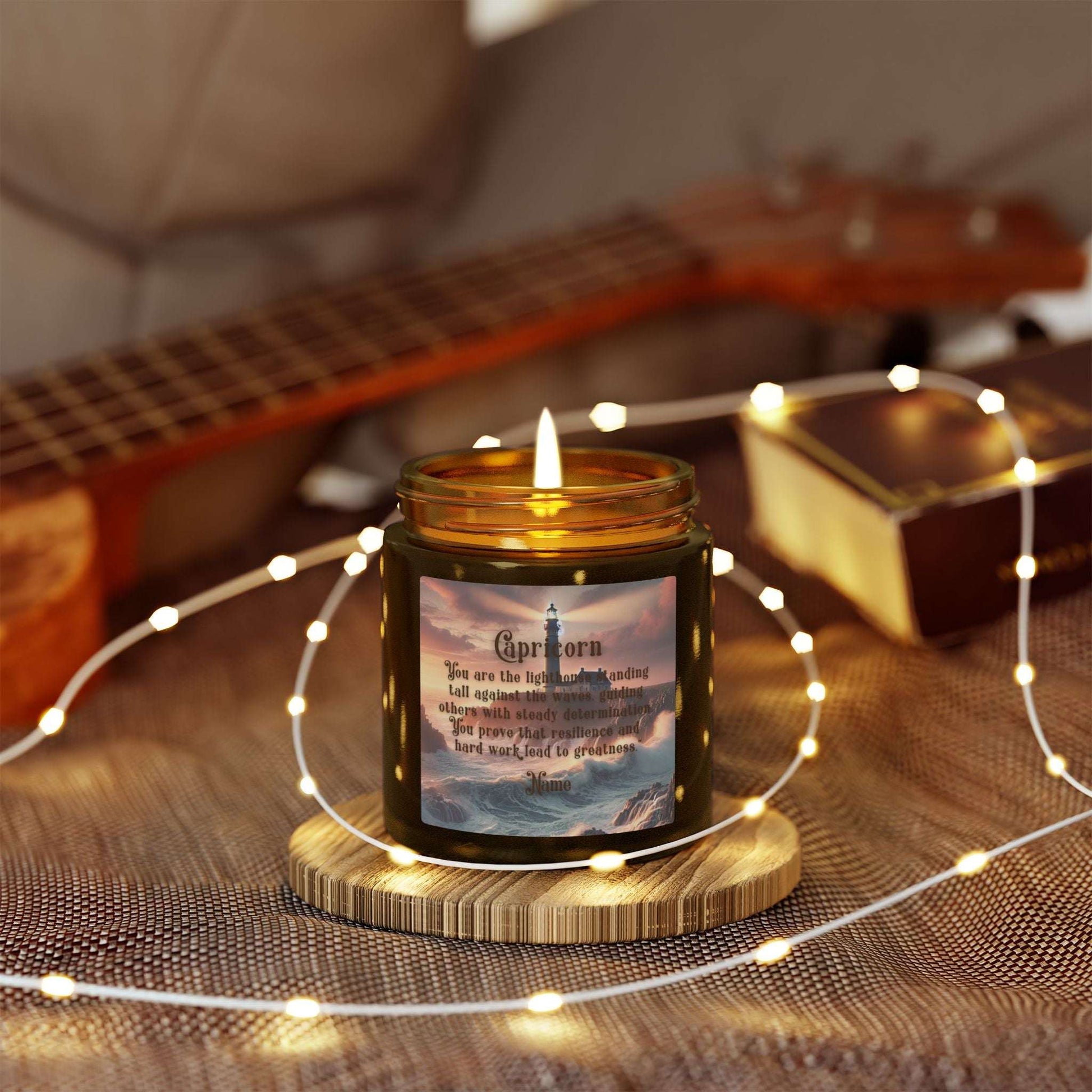 Candle with Capricorn design on a wooden coaster surrounded by string lights and a guitar in the background