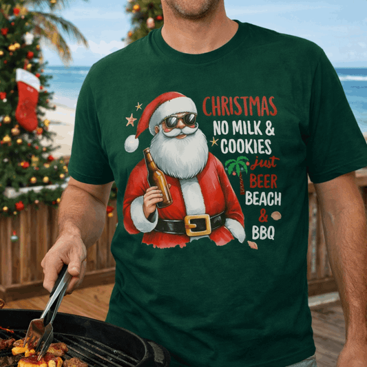 Person wearing a green t-shirt with a Santa Claus holding a beer and wearing sunglasses graphic and text Christmas No Milk & Cookies just Beer Beach & BBQ.