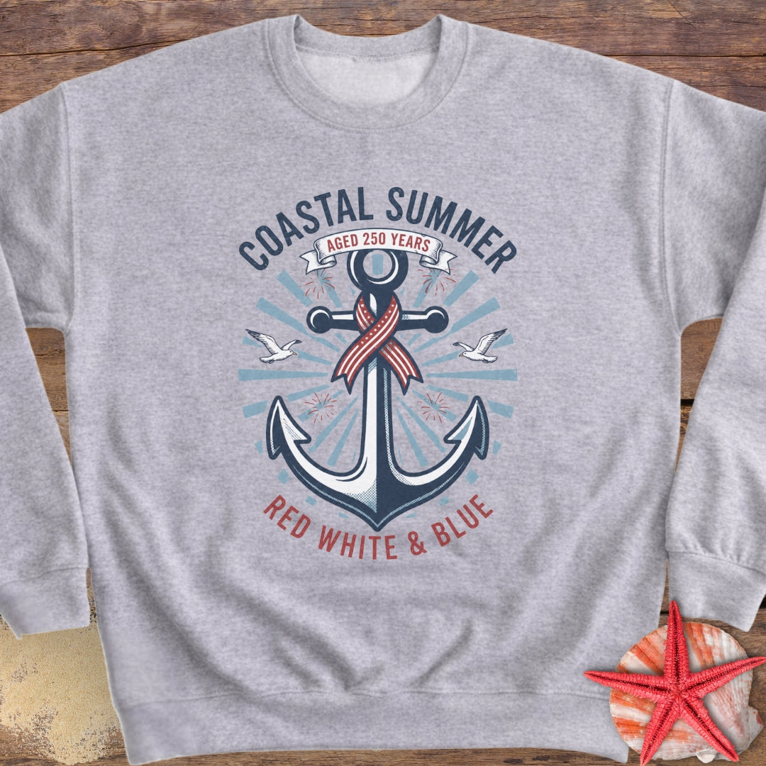 Gray sweatshirt with an anchor design and 'Coastal Summer' text on a wooden surface.