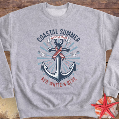 Gray sweatshirt with an anchor design and 'Coastal Summer' text on a wooden surface.