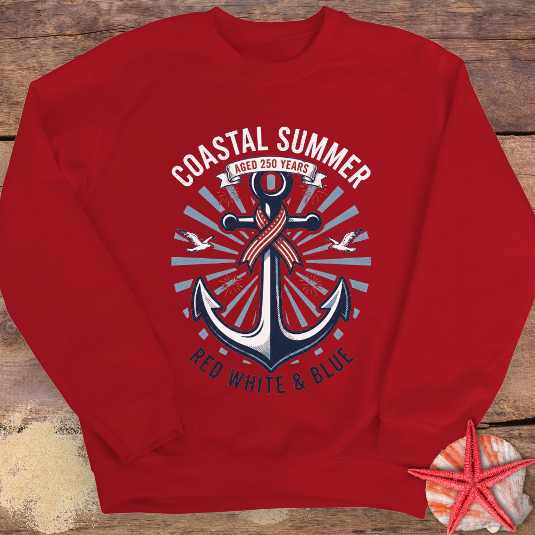 Red sweatshirt with anchor design and 'Coastal Summer' text on a wooden surface.