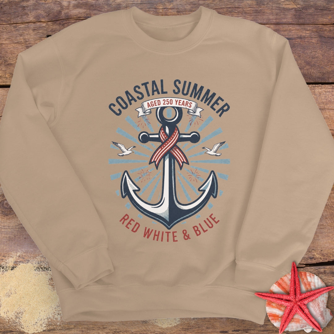 Beige sweatshirt with an anchor design and 'Coastal Summer' text on a wooden surface.
