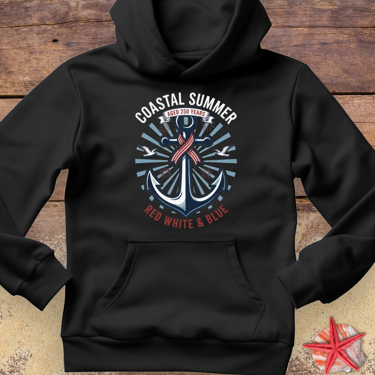 Black hoodie with a coastal design featuring an anchor on a wooden surface.