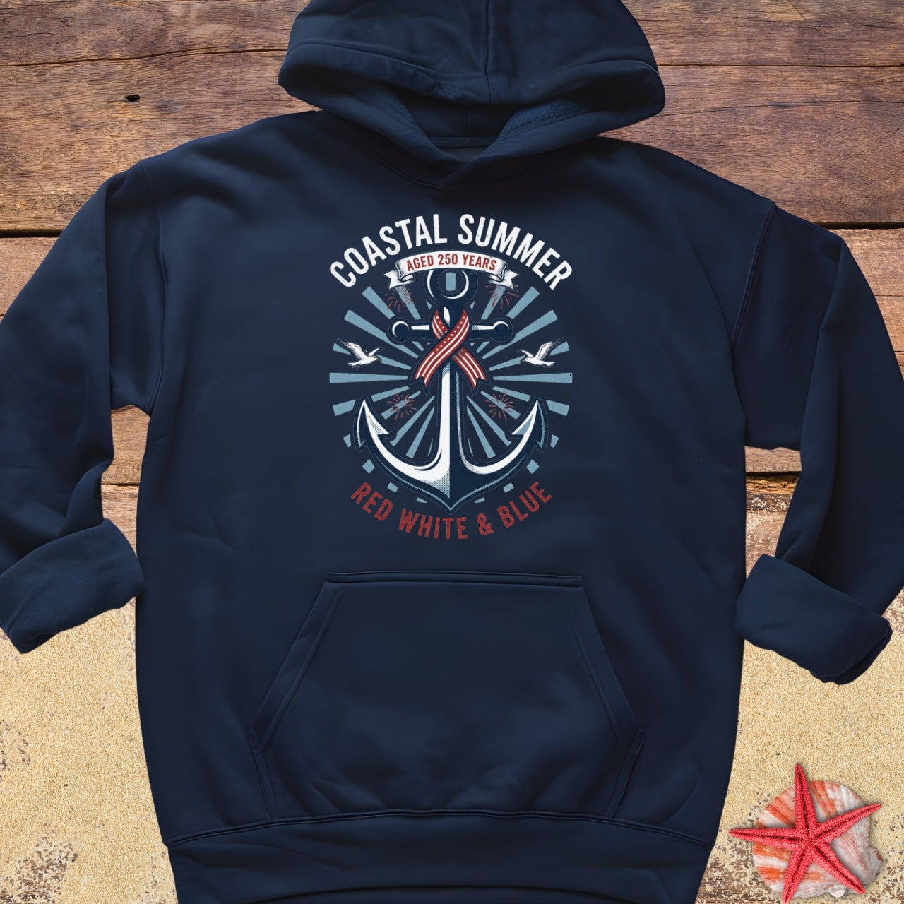 Navy blue hoodie with an anchor design and text on a wooden surface.