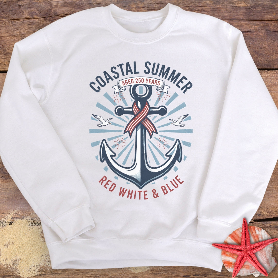 White sweatshirt with anchor design and 'Coastal Summer' text on a wooden surface.