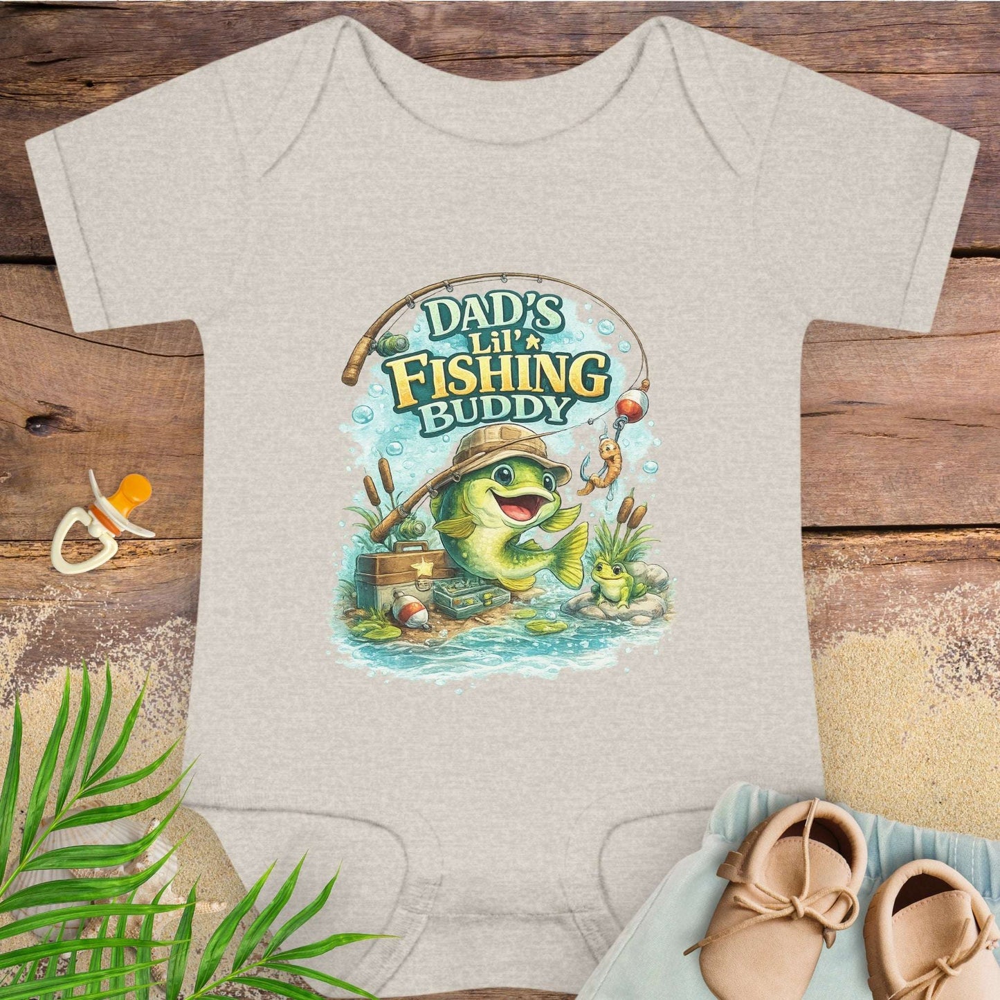Beige baby onesie with 'Dad's Lil' Fishing Buddy' design.
