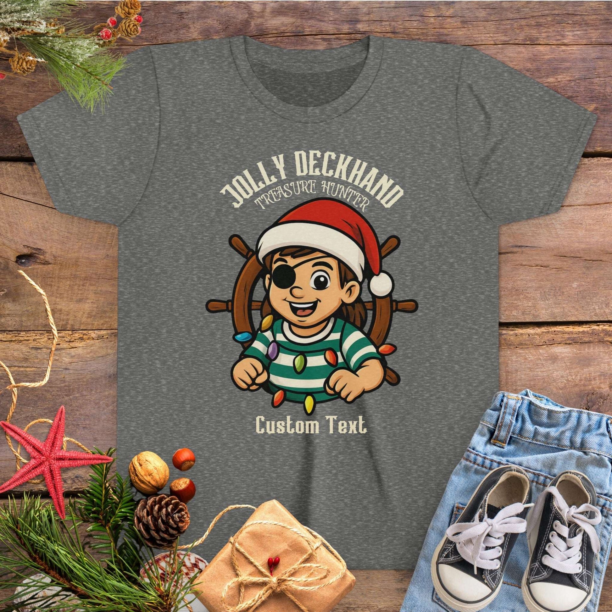 Gray t-shirt with Christmas-themed design featuring a cartoon girl pirate character and text 'Jolly Deckhand Treasure Hunter' that can be personalized.