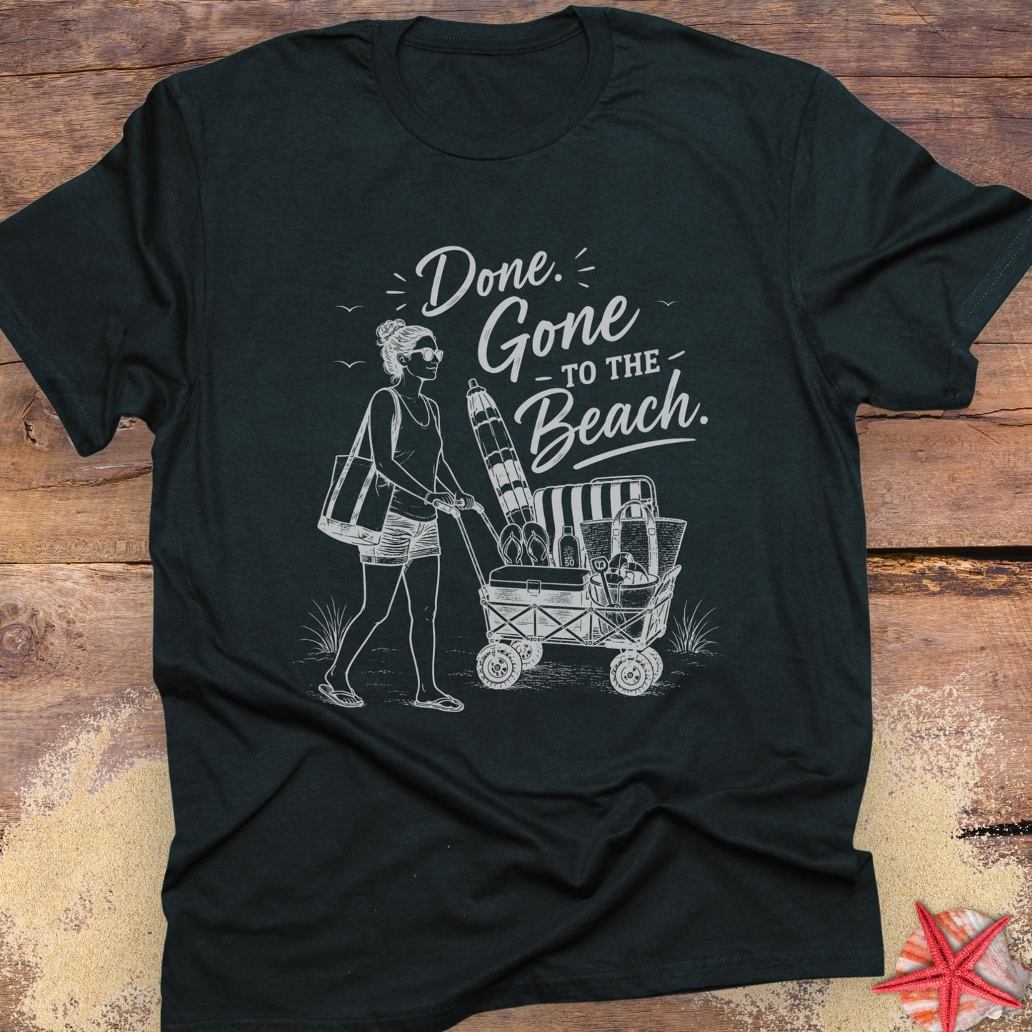 Black unisex t-shirt with a woman pushing a cart of beach equipment and text "Done. Gone to the Beach."