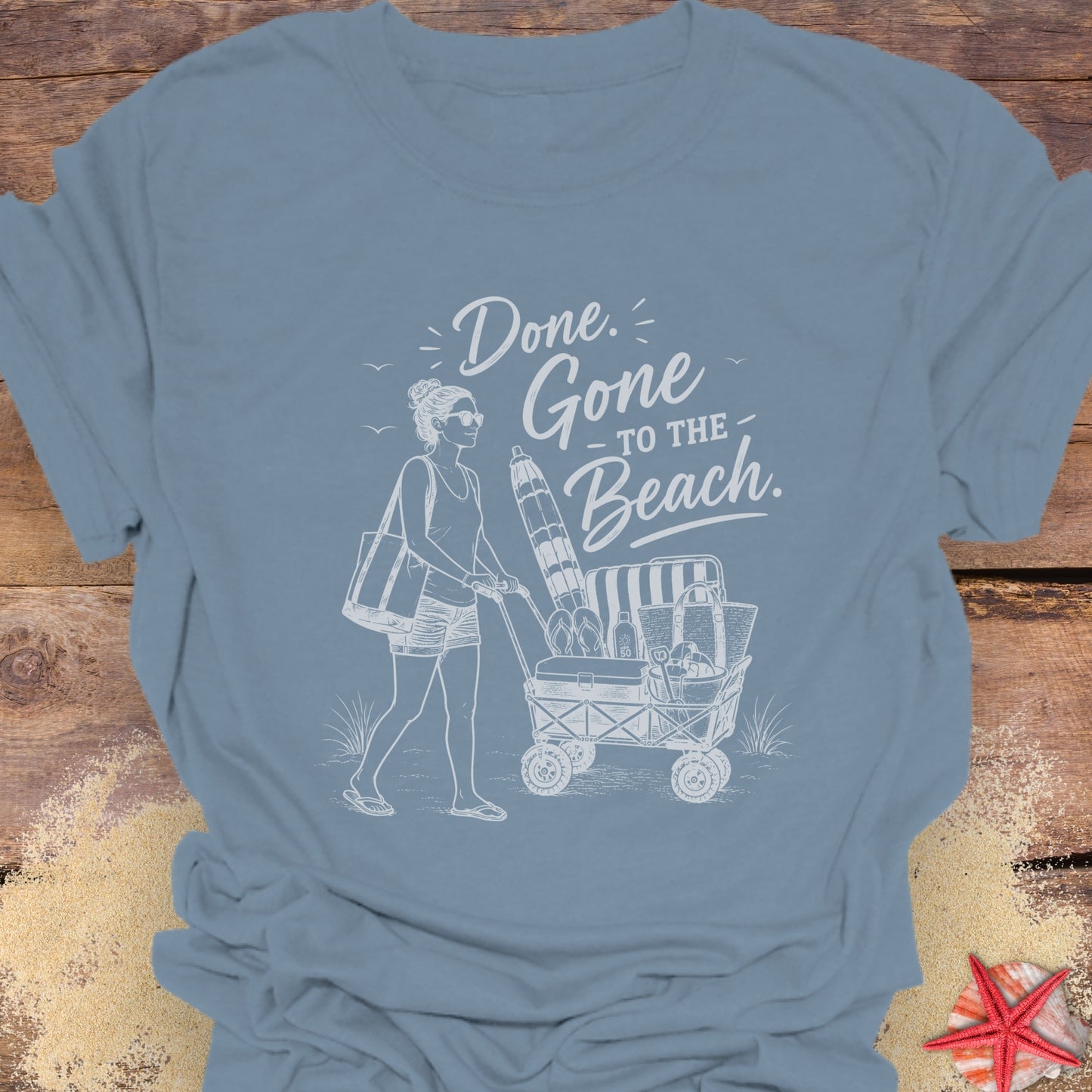 Stone Blue unisex t-shirt with a woman pushing a cart of beach equipment and text "Done. Gone to the Beach."