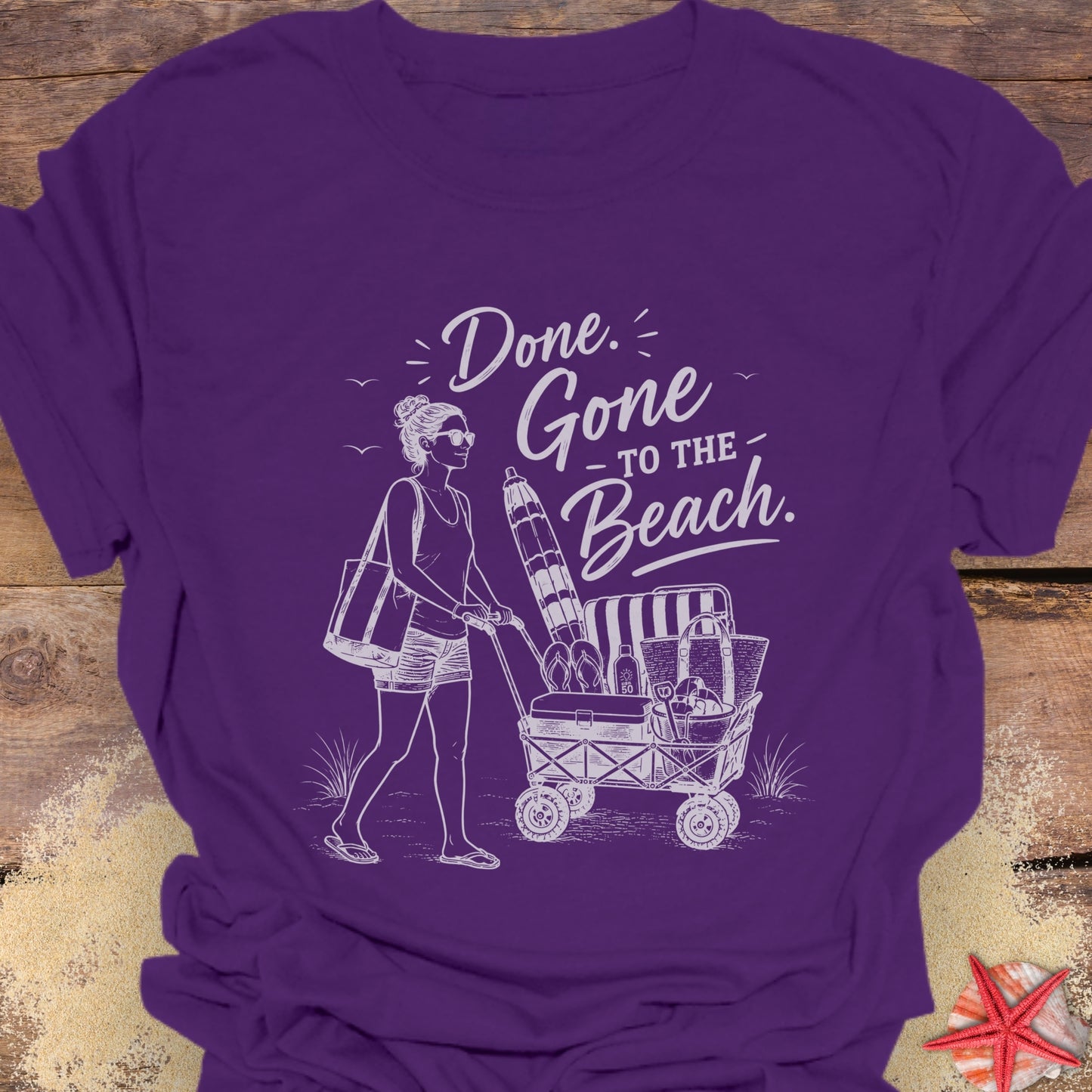 Purple unisex t-shirt with a woman pushing a cart of beach equipment and text "Done. Gone to the Beach."