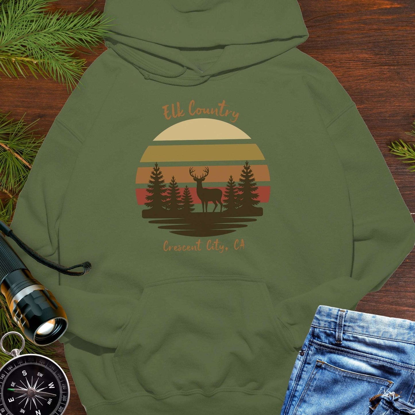 Green hoodie with 'Elk Country' with retro sunset and silhouette of trees and elk design with Crescent City, CA underneath.