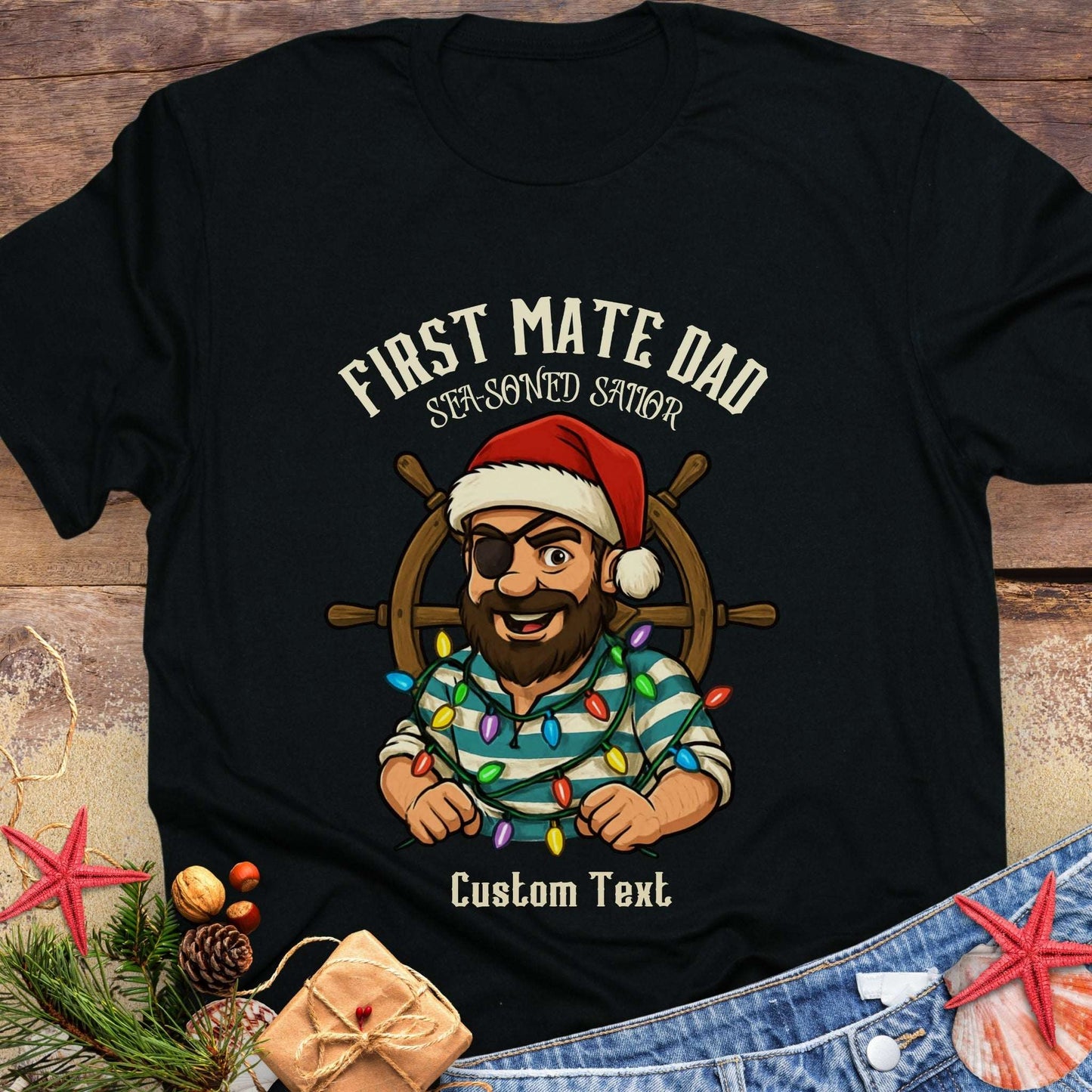 Black t-shirt with a graphic of a man in a Santa hat and pirate outfit, surrounded by Christmas lights and  'First Mate Dad' text that can be personalized.