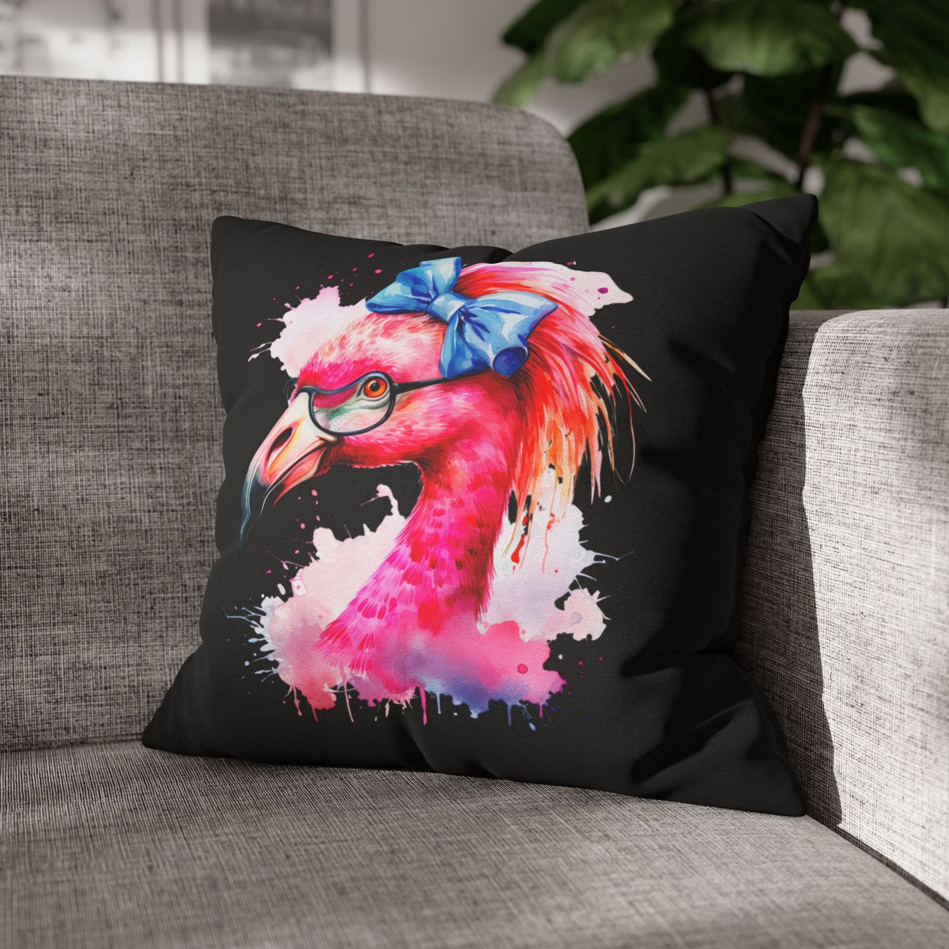 Decorative square pillowcase featuring a flamingo head wearing glasses and a big blue bow on a black background.