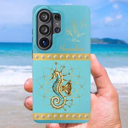 Phone case with seahorse design held by a hand on a beach