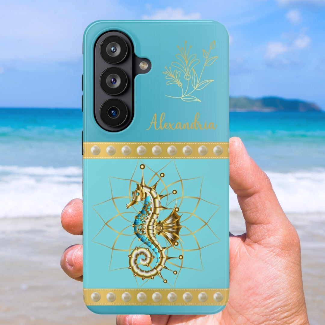 Phone case with seahorse design held by a hand on a beach
