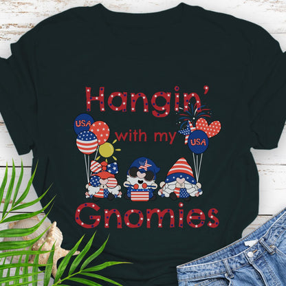 Black T-shirt with three gnomes in patriotic outfits holding flag balloons with sun and fireworks in the background with the phrase Hangin' with my Gnomies.