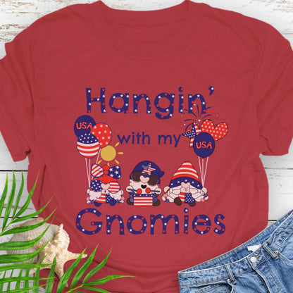 Cherry Red T-shirt with three gnomes in patriotic outfits holding flag balloons with sun and fireworks in the background with the phrase Hangin' with my Gnomies.