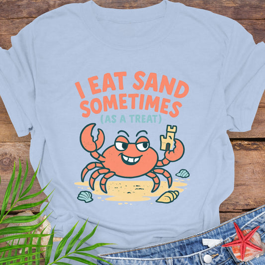 Light blue I Eat Sand Sometimes as a Treat shirt featuring crab holding sandcastle.