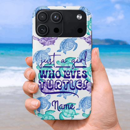 iPhone 17 Pro Max phone case with turtle design and text 'Just a girl who loves turtles' held by a hand on a beach.