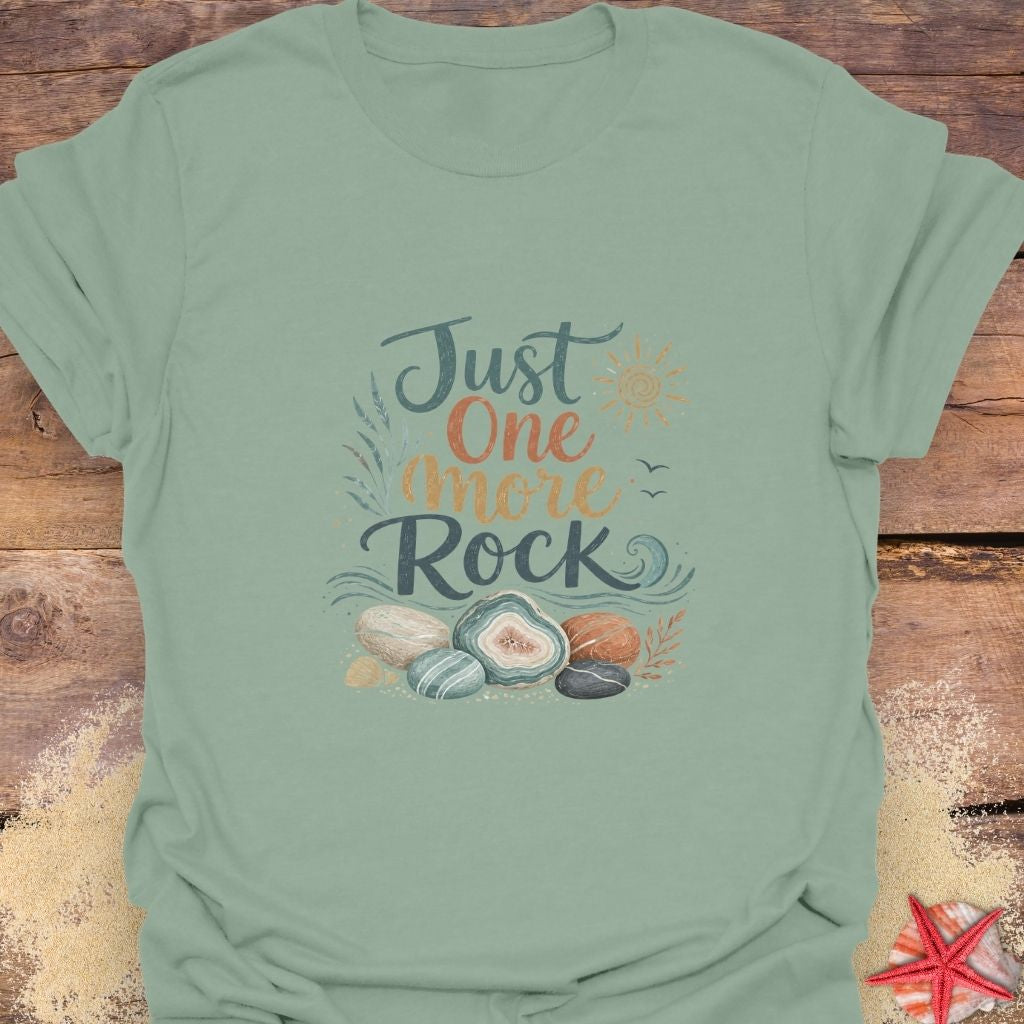 A sage green "Just One More Rock" graphic  unisex t-shirt featuring colorful beach stones and agates.