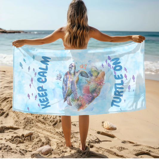 Light blue tie-dye beach towel with sea turtle and phrase “Stay Calm Turtle On”.