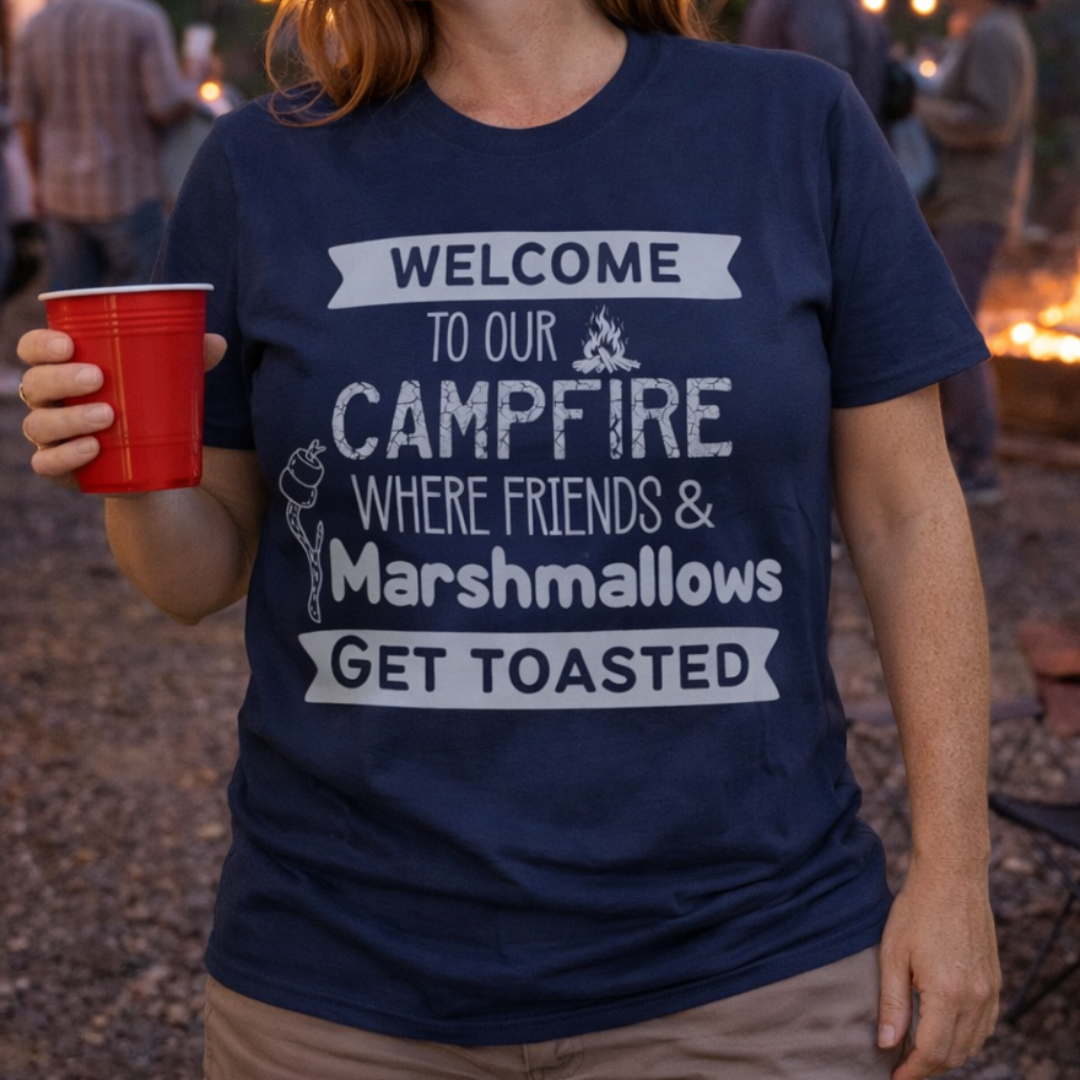 Person wearing a navy blue t-shirt with a campfire friends marshmallows get toasted text
