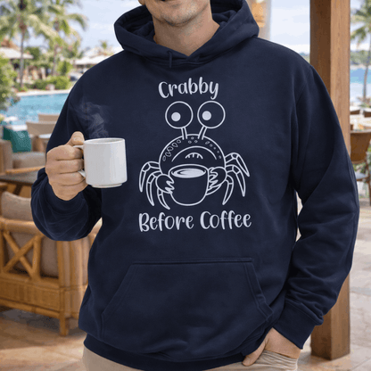 Man wearing a navy hoodie with a crab graphic and text crabby before coffee.