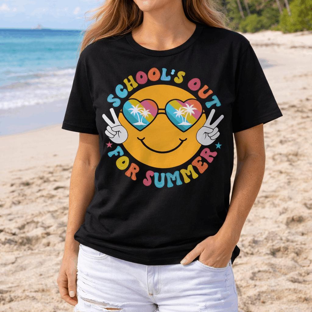 Woman wearing a black t-shirt with 'School's Out for Summer' text with a smiley face with tropical heart glasses and showing the peace sign