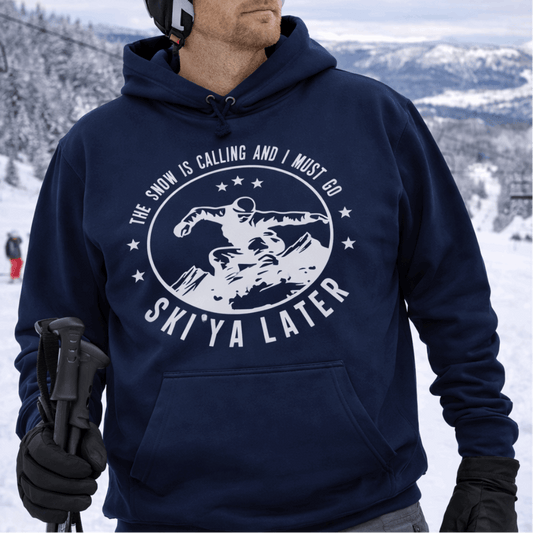 Person wearing a navy hoodie with a skiing design and text Snow is Calling and I Must Go Ski Ya Later.