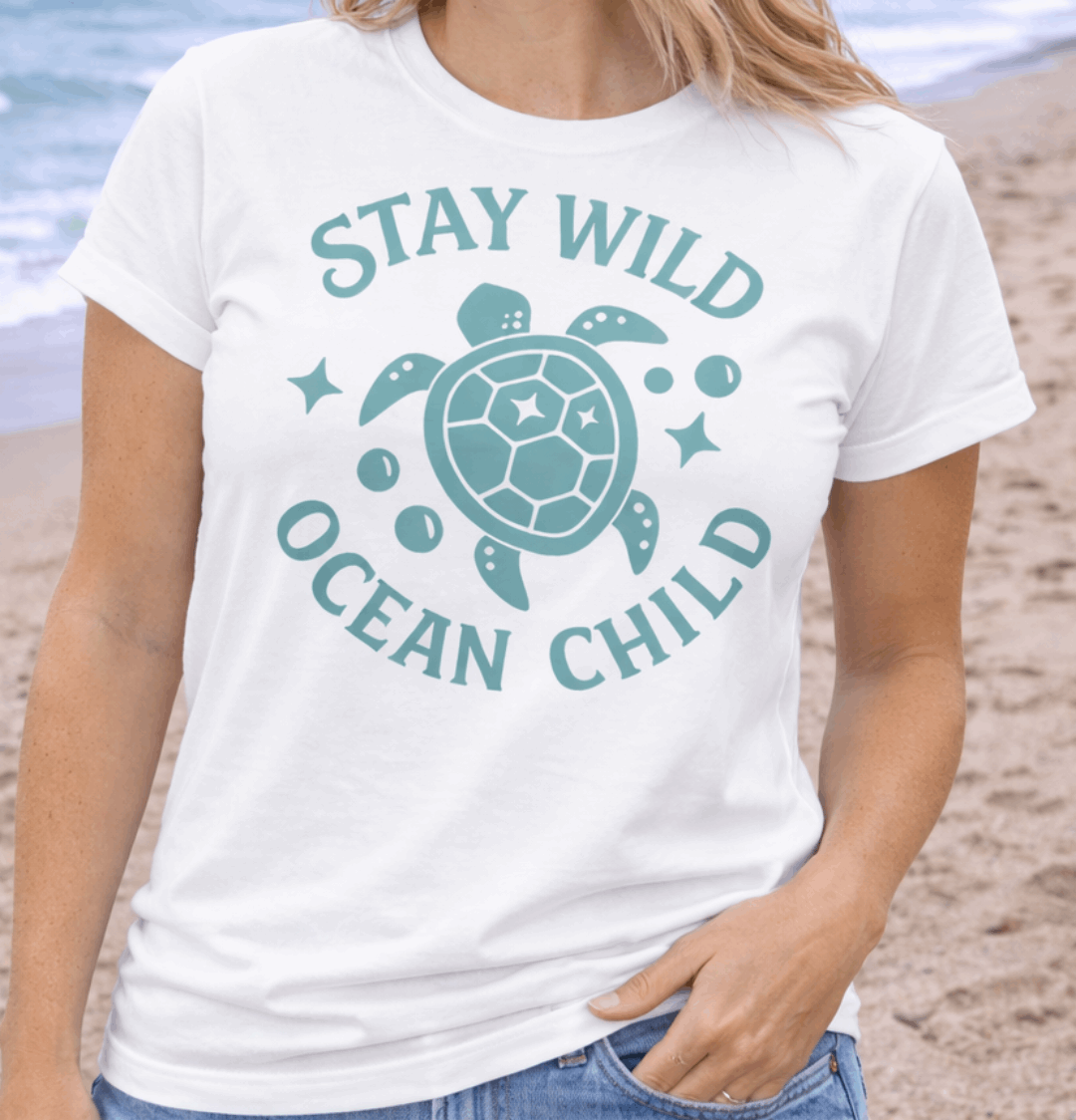 Woman wearing a 'Stay Wild Ocean Child' t-shirt on a beach