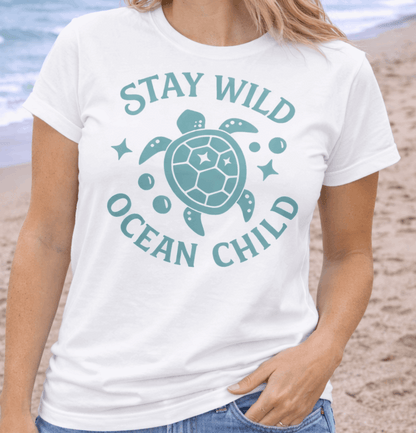 Woman wearing a 'Stay Wild Ocean Child' t-shirt on a beach