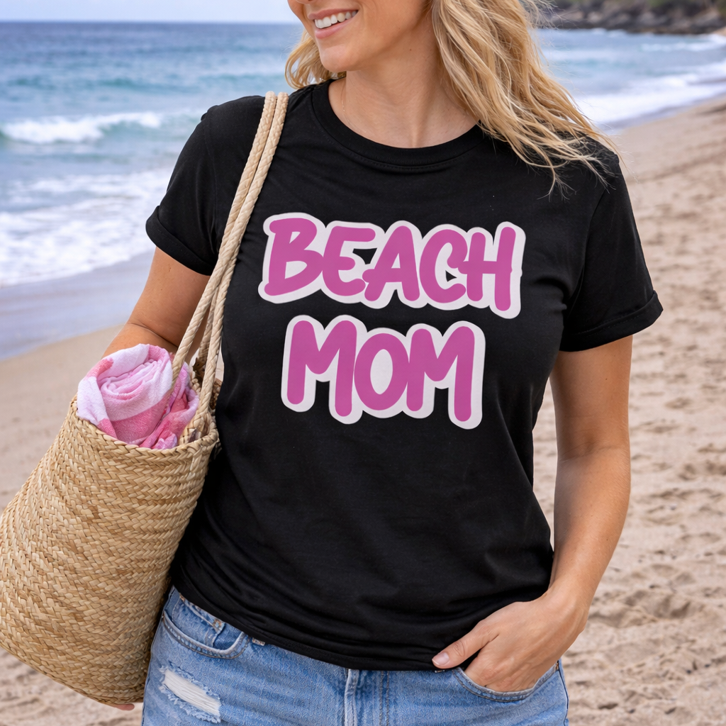 Woman on a beach wearing a black t-shirt with 'BEACH MOM' text.