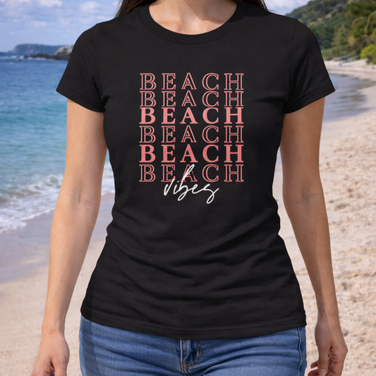 Person wearing a black t-shirt with 'BEACH VIBES' text on a beach