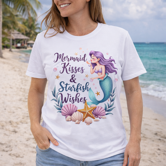 Person wearing a white t-shirt with a mermaid design with text Mermaid Kisses & Starfish Wishes.