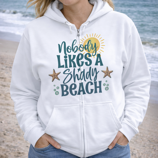 Woman wearing a white hoodie with a beach-themed Nobody Likes a Shady Beach design.