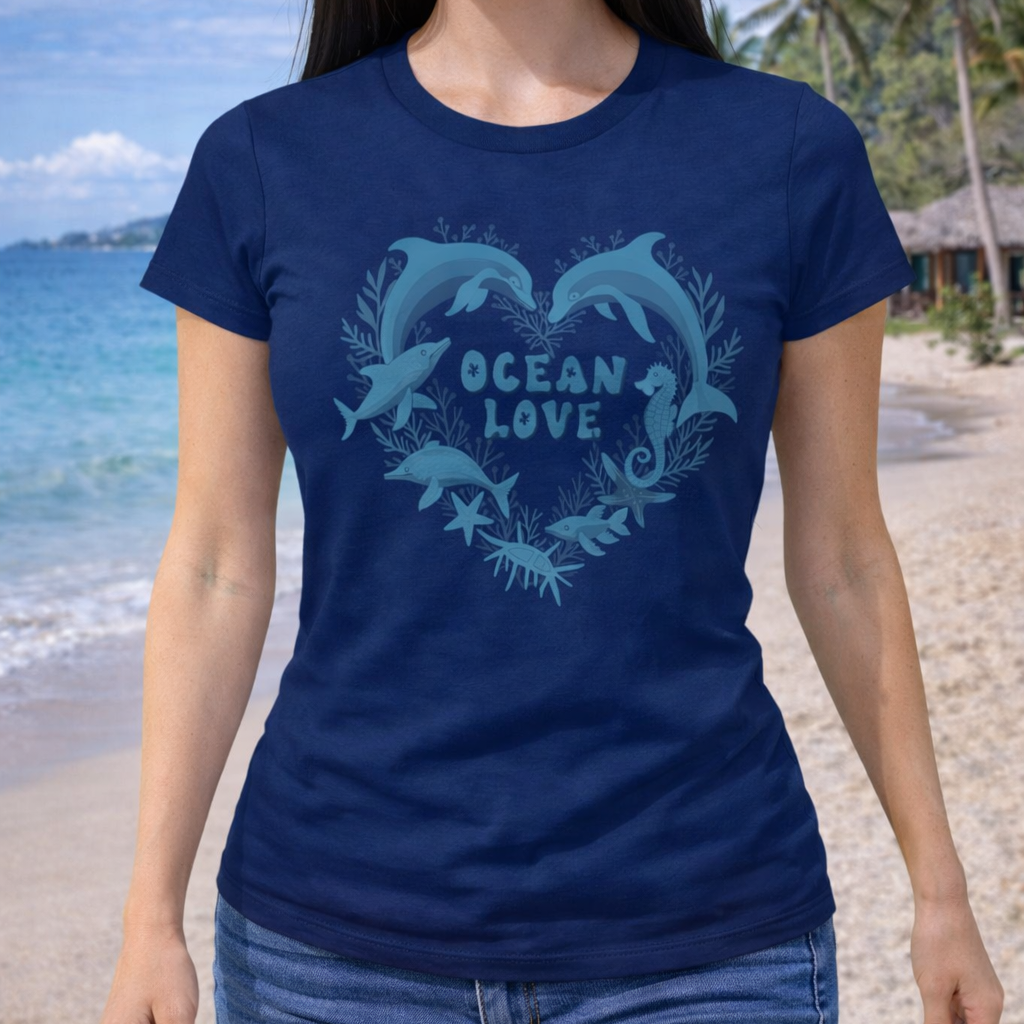 Person wearing a blue 'Ocean Love' woman's t-shirt with dolphin design on a beach.