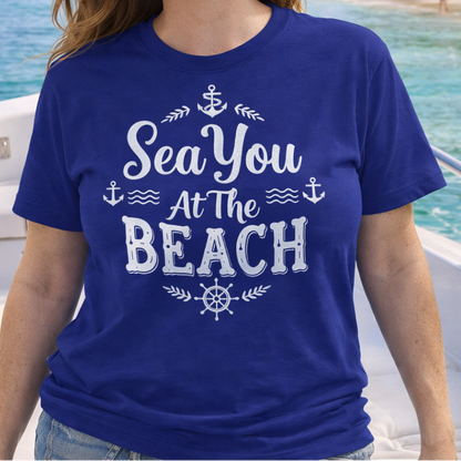 Woman wearing a blue t-shirt with 'Sea You At The Beach' text on a boat by the beach.